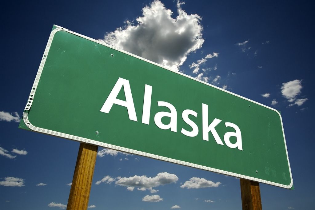 Photo of Save Download Preview Alaska Road Sign with dramatic clouds and sky. Concept of Alaska detox.